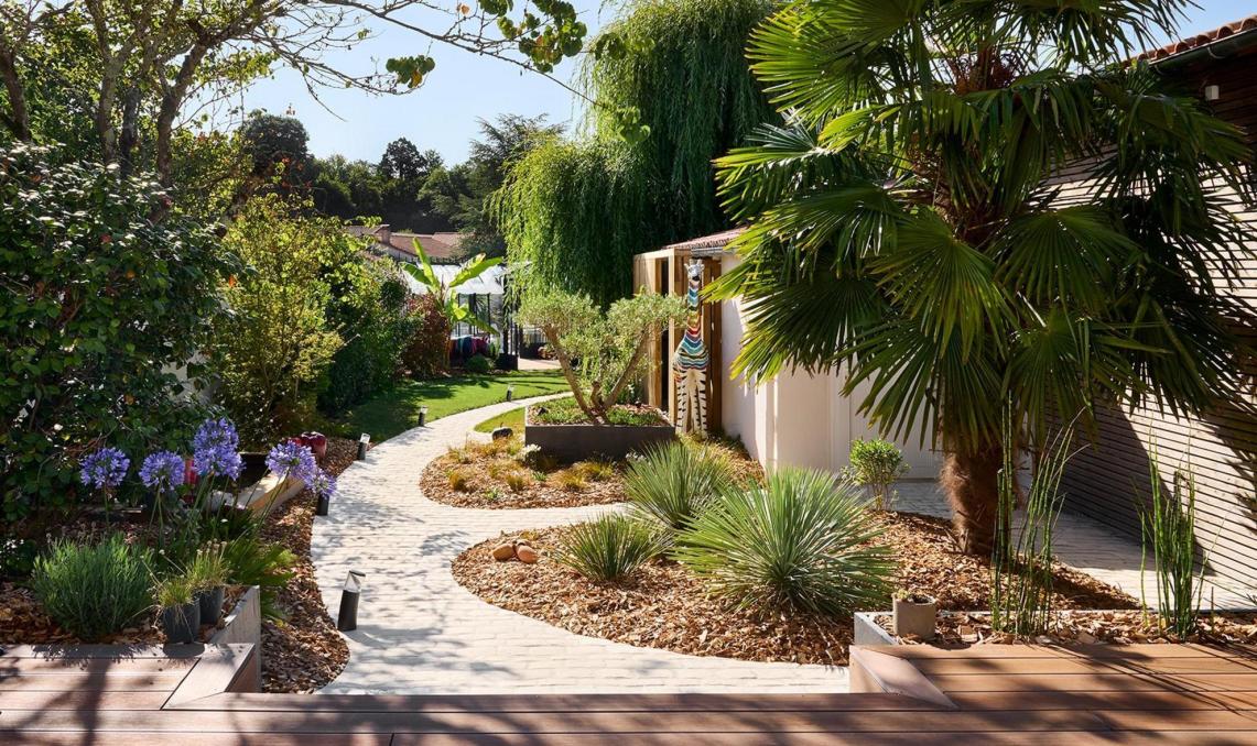 Pool-house contemporain à bardage bois cintré et terrasse composite Nuances Ipé, réalisation O'xygen Paysagist