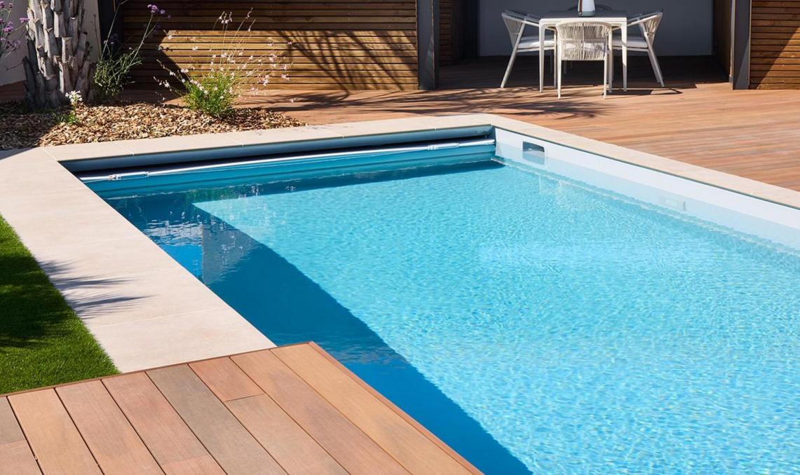 Terrasse composite Nuances Ipé en plage de piscine, vue latérale avec pool-house et palmiers, résidence privée